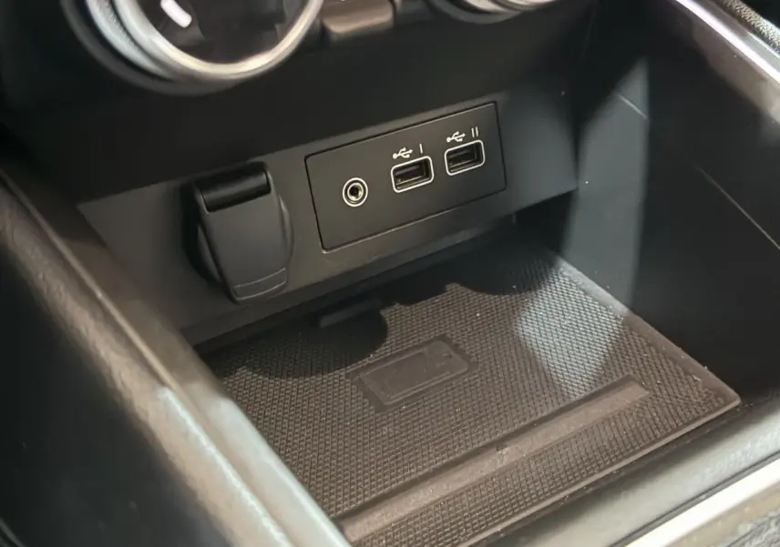 Gros plan sur la console centrale noire de la Renault Clio Techno TCe 90 avec ports USB et prise 12V visibles.