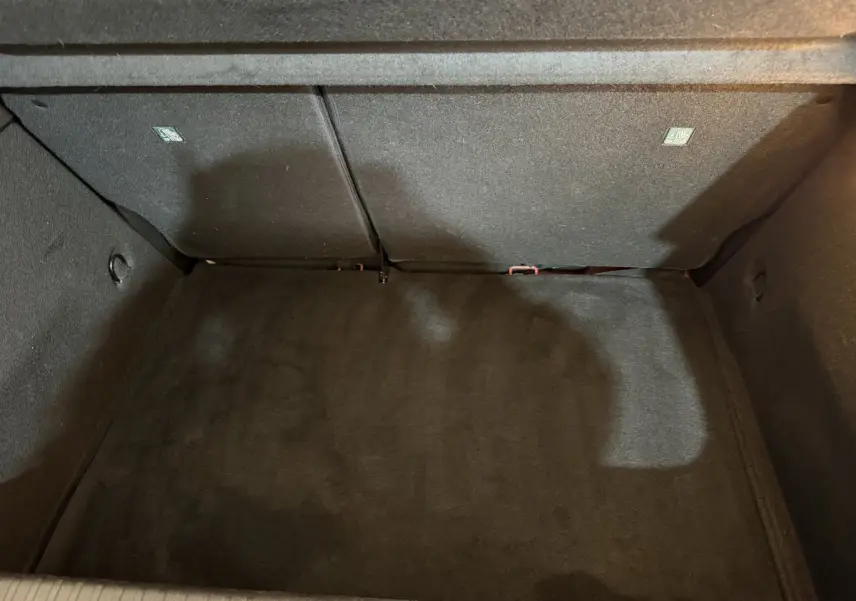 Vue intérieure du coffre spacieux et tapissé en noir de la Renault Clio Techno TCe 90 rouge 2024.