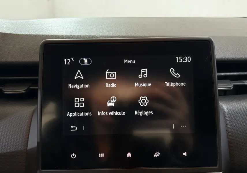 Écran tactile central de la Renault Clio Business blanc 2021 affichant le menu principal avec navigation et musique.