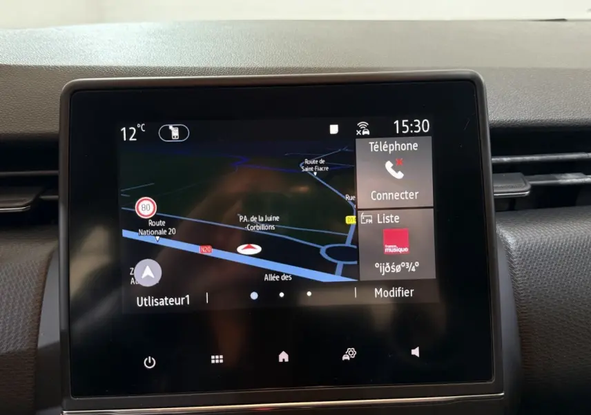 Écran tactile central du tableau de bord de la Renault Clio Business blanc, affichant la navigation et les options multimédia.
