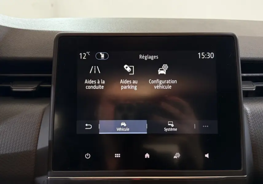 Écran tactile central de la Renault Clio Business blanc 2021 affichant les réglages d’aides à la conduite et parking.