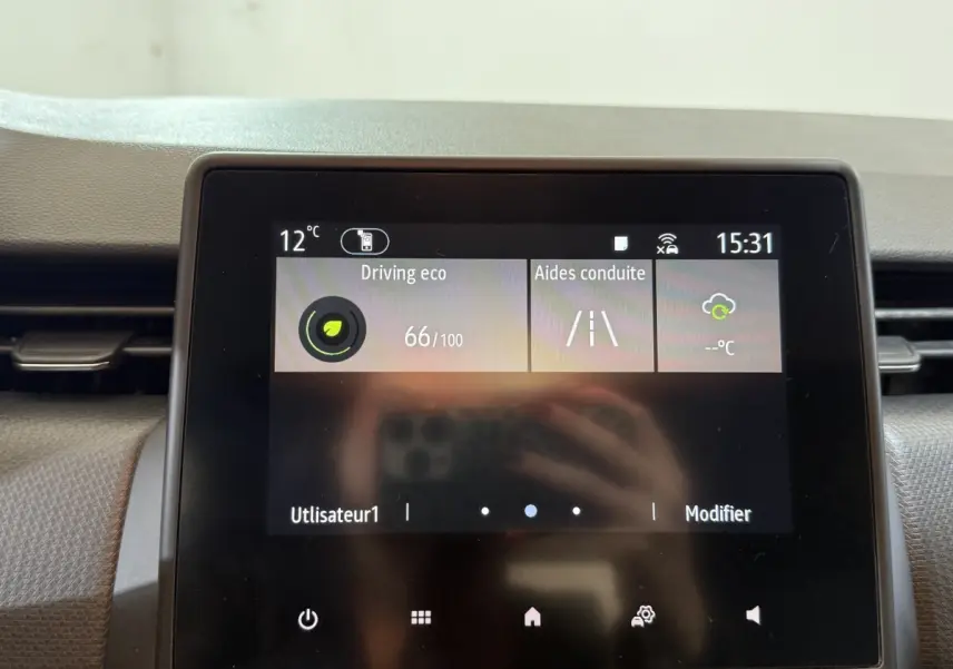 Écran tactile central de la Renault Clio Business blanc, affichant les aides à la conduite et la température extérieure.