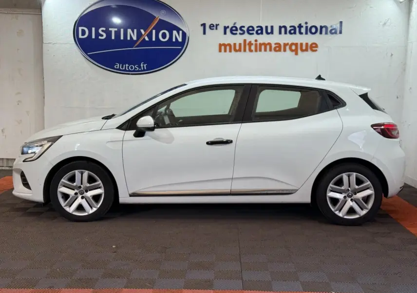 Profil droit d'une Renault Clio blanche Business SCe 65 de 2021, avec jantes alliage et feux arrière LED visibles.