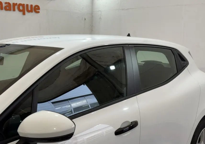 Vue latérale droite d'une Renault Clio Business blanche, avec rétroviseur et poignée de porte noirs visibles.