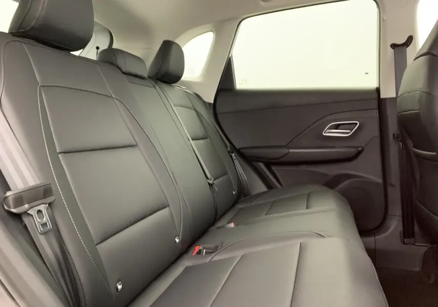 Vue latérale droite de l'intérieur arrière du MG ZS 1.5 L Hybrid+ 2026, sièges en similicuir noir avec ceintures visibles.