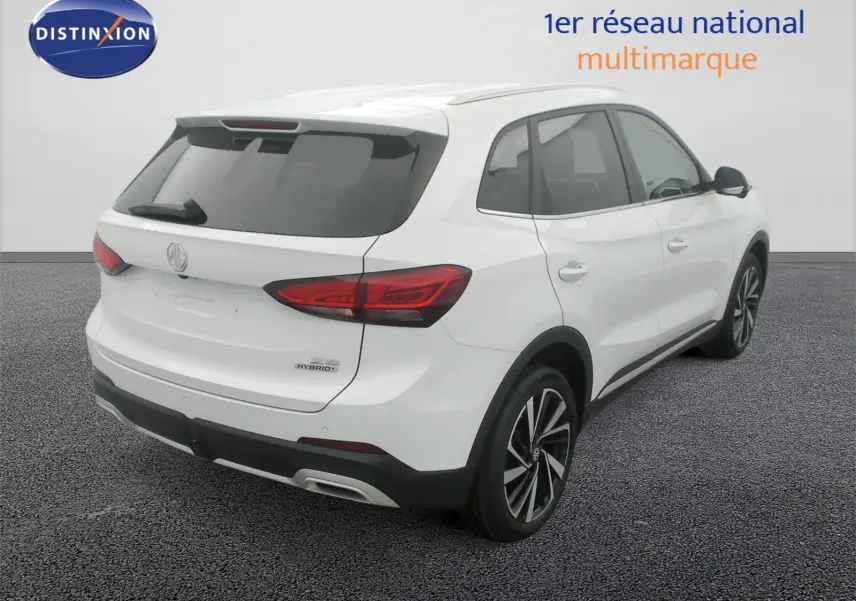 Vue 3/4 arrière droit du MG ZS 1.5 L Hybrid+ Dover White avec jantes alliage 18 pouces et vitres surteintées.