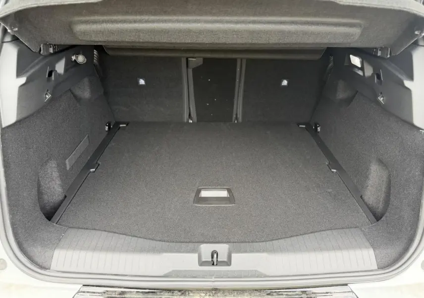 Coffre ouvert vu de l'arrière d'un Citroën C5 Aircross blanc, espace de chargement spacieux et tapis noir.