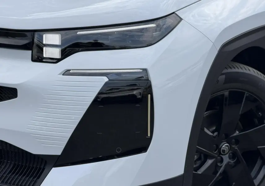 Gros plan sur l'avant droit blanc Okenite du Citroën C5 Aircross 2026 avec optique LED et jante noire.