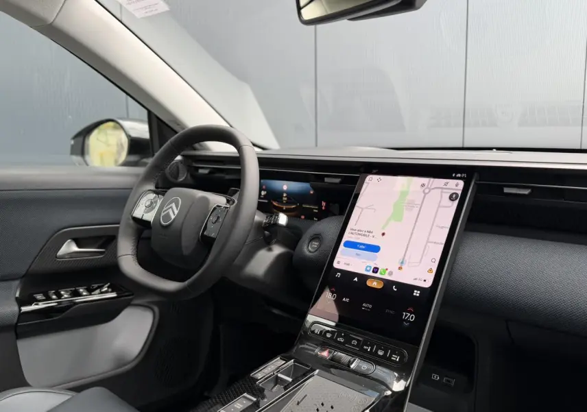 Vue intérieure côté conducteur du Citroën C5 Aircross 2026, tableau de bord noir avec écran tactile vertical et volant multifonctions.