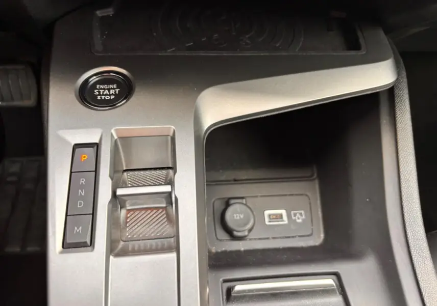 Vue rapprochée de la console centrale grise de la Peugeot 308 Hybrid 145 e-DCS6 Allure avec bouton start/stop et levier de vitesses automatique.