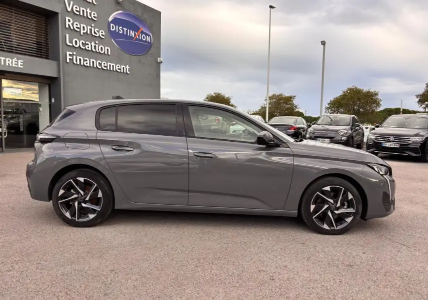 Peugeot 308 gris vue de profil côté gauche, jantes alliage 17 pouces et vitres teintées visibles.