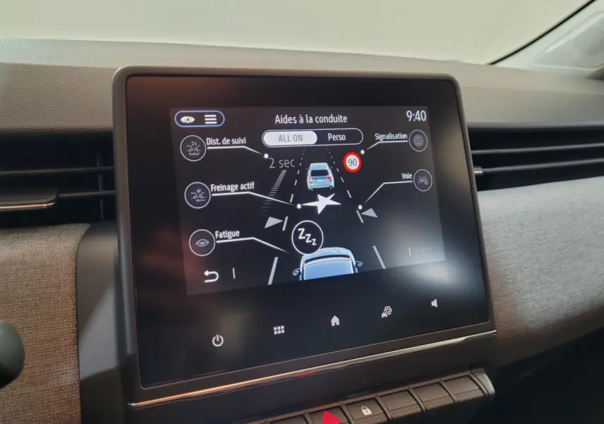 Écran tactile central du tableau de bord de la Renault Clio bleu 2025 montrant les aides à la conduite.