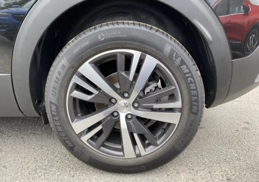 Gros plan sur la roue avant droite du Peugeot 3008 noir Perla Nera avec jante alliage et pneu Michelin.