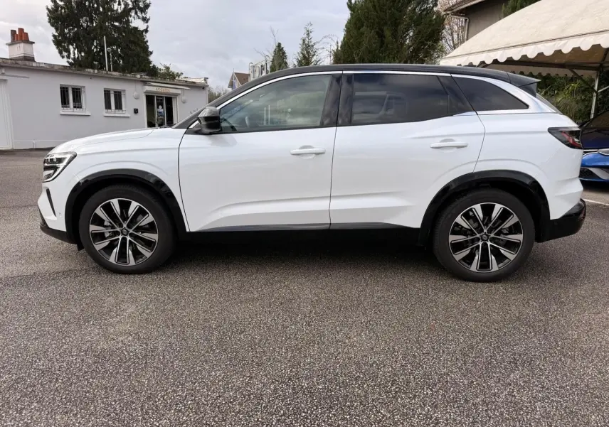 Profil droit d'un Renault Austral E-Tech 200 blanc nacré avec toit noir, roues alliage et détails noirs contrastants.