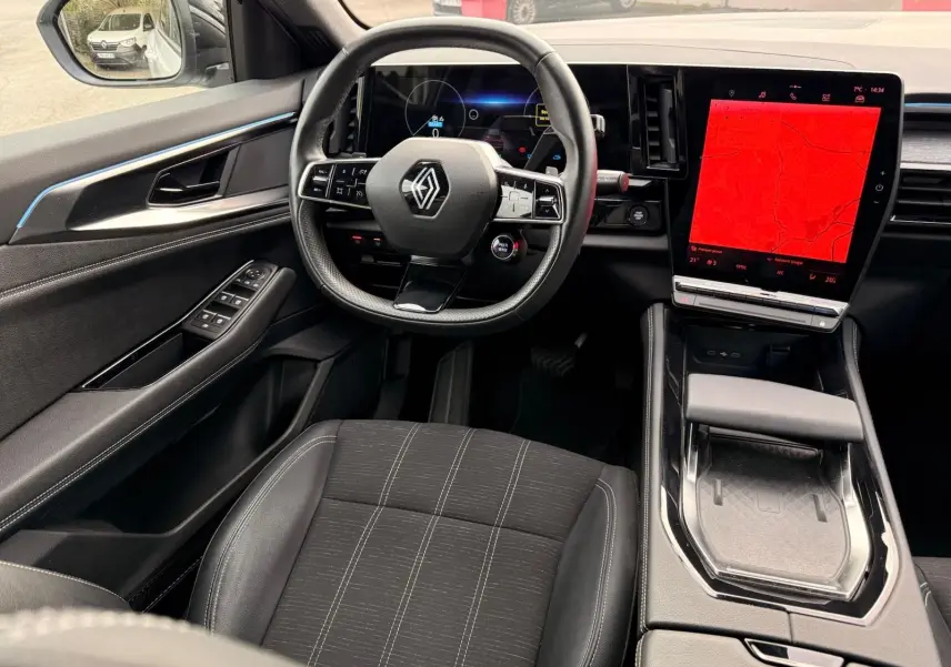Intérieur Renault Austral E-Tech 200 hybride, vue côté conducteur sur volant, écran tactile vertical et sièges noirs.