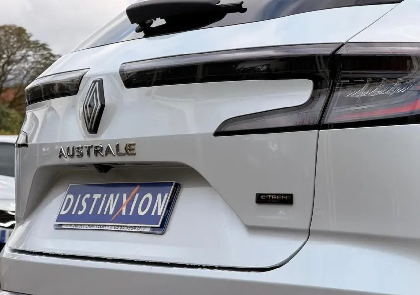 Gros plan arrière droit du Renault Austral blanc nacré avec logo E-TECH et feux arrière noirs soulignés de rouge.