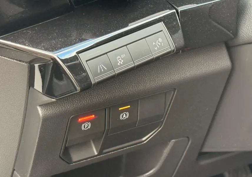 Gros plan sur les commandes de sécurité et assistance du tableau de bord du Renault Austral E-Tech 200 blanc nacré.