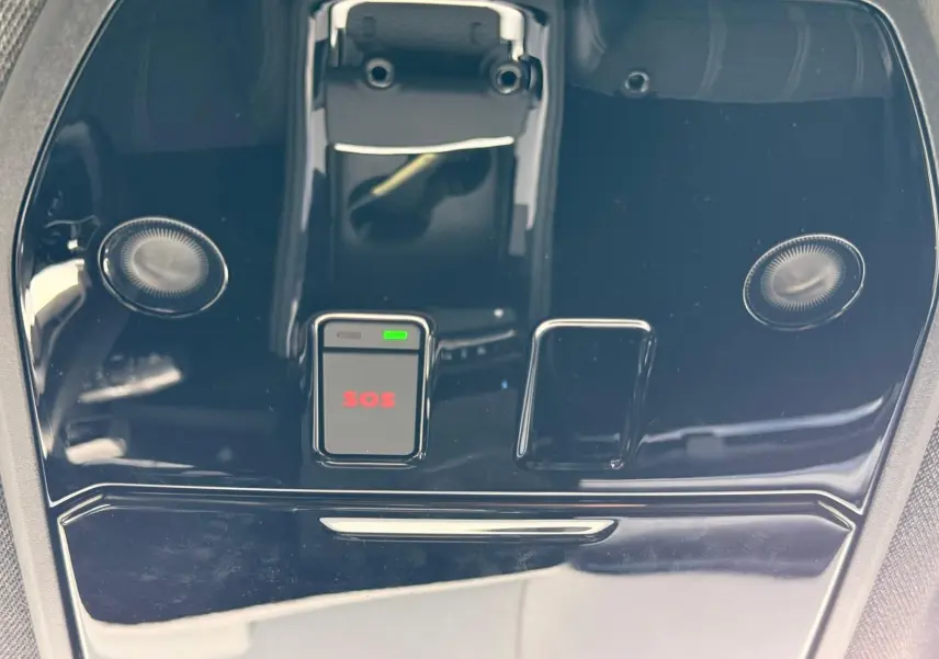 Gros plan sur la console de toit noire brillante du Renault Austral E-Tech 200 blanc nacré avec bouton SOS rouge.