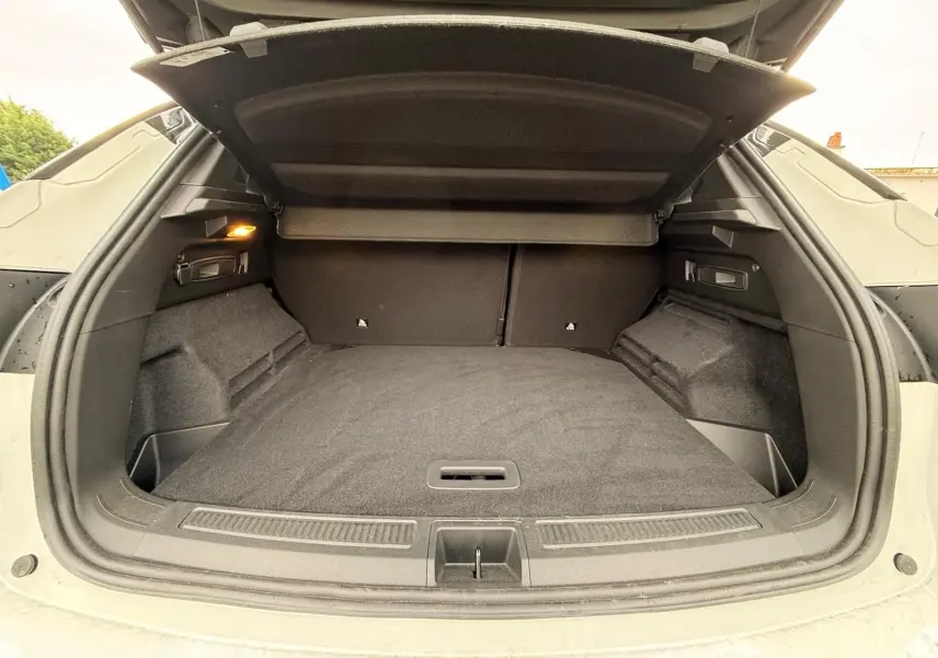 Coffre ouvert du Renault Austral E-Tech 200 blanc nacré avec toit noir, montrant un espace de chargement spacieux et bien fini.