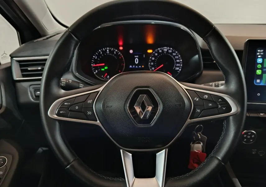 Vue rapprochée du volant cuir multifonctions noir de la Renault Clio 2023 avec tableau de bord et écran tactile.