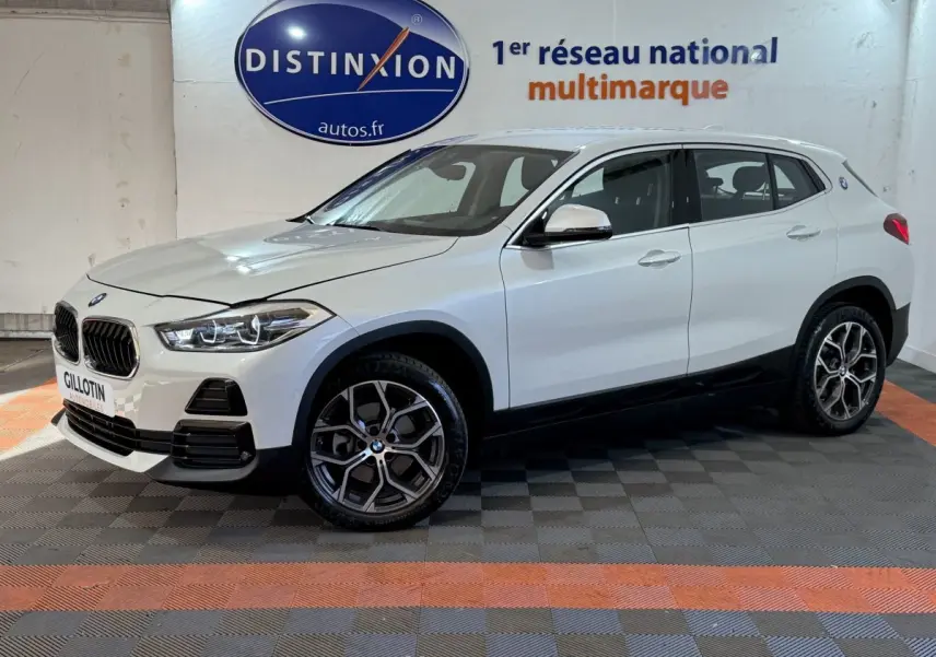 BMW X2 sDrive18i Lounge blanc en vue de profil côté gauche, avec jantes alliage et calandre caractéristique.