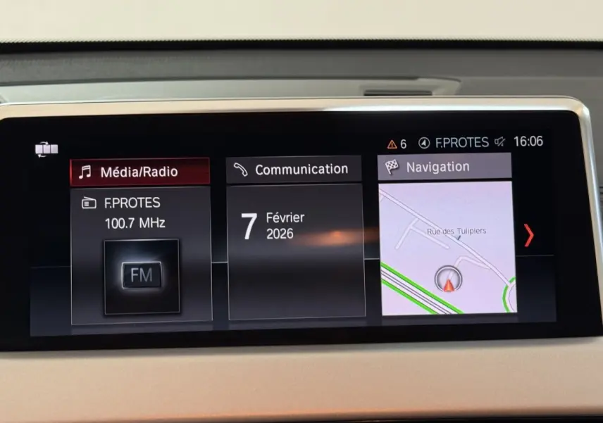 Écran central du tableau de bord du BMW X2 blanc 2023 affichant radio, communication et navigation.