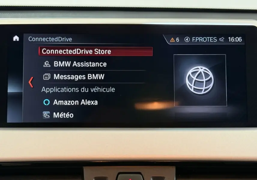 Écran central du tableau de bord du BMW X2 sDrive18i 2023 affichant le menu ConnectedDrive en intérieur beige.