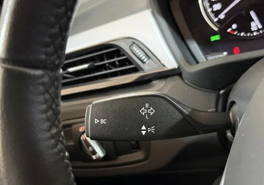 Gros plan sur la manette de clignotant noire dans l'habitacle du BMW X2 sDrive18i Lounge 2023.