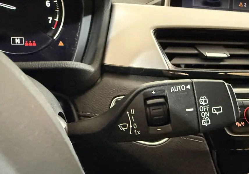 Gros plan sur la commande d’essuie-glace côté droit du tableau de bord intérieur d’une BMW X2 blanche 2023.