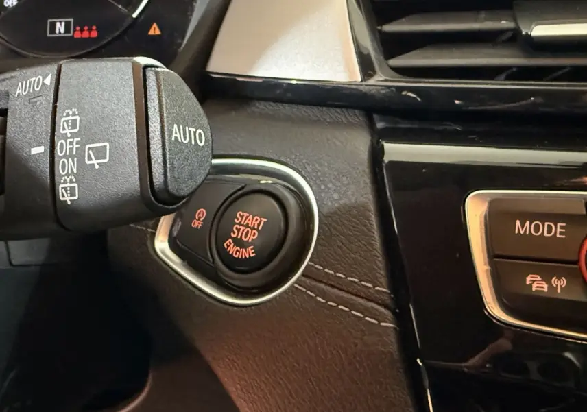 Gros plan sur le bouton Start Stop Engine rouge dans l’habitacle noir et beige du BMW X2 sDrive18i Lounge 2023.