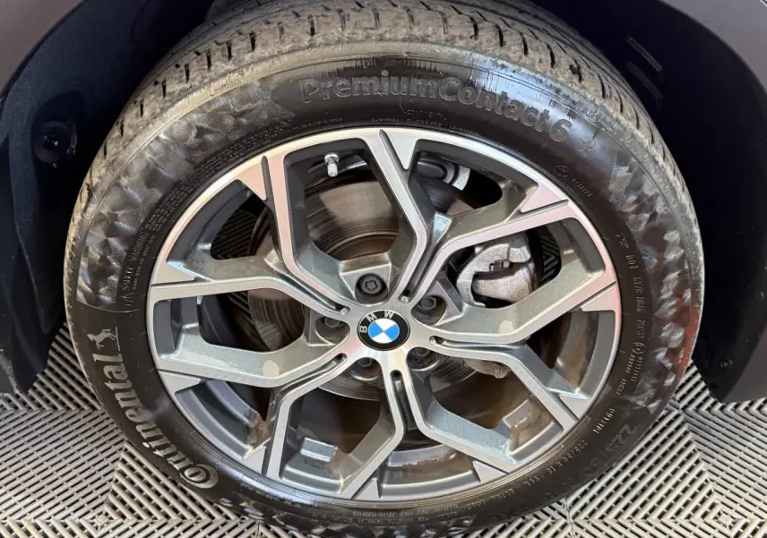 Gros plan sur la jante alliage grise avec logo BMW au centre, montée sur pneu Continental PremiumContact 6.