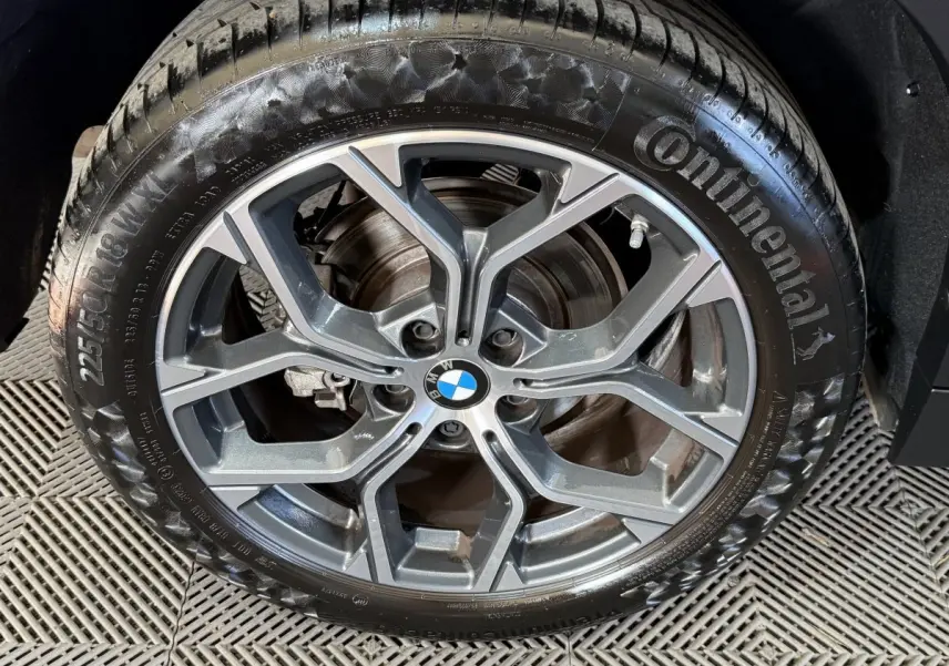 Gros plan sur la jante alliage grise et le pneu Continental du BMW X2 sDrive18i Lounge blanc, roue avant droite.