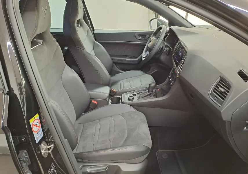 Vue intérieure côté conducteur du CUPRA Ateca 2024 noir magique, sièges sport en alcantara avec surpiqûres orange.