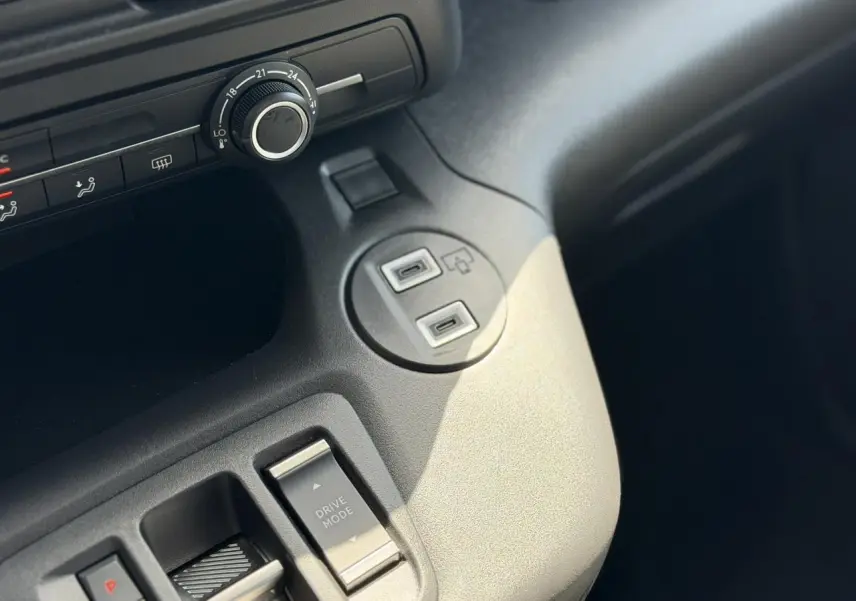 Détail de la console centrale grise du Citroën Berlingo ë-136, avec commandes Drive Mode et ports USB visibles.