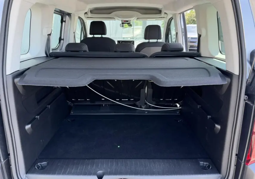 Vue arrière du coffre du Citroën Berlingo gris Artense avec tablette cache-bagages et sièges arrière visibles.