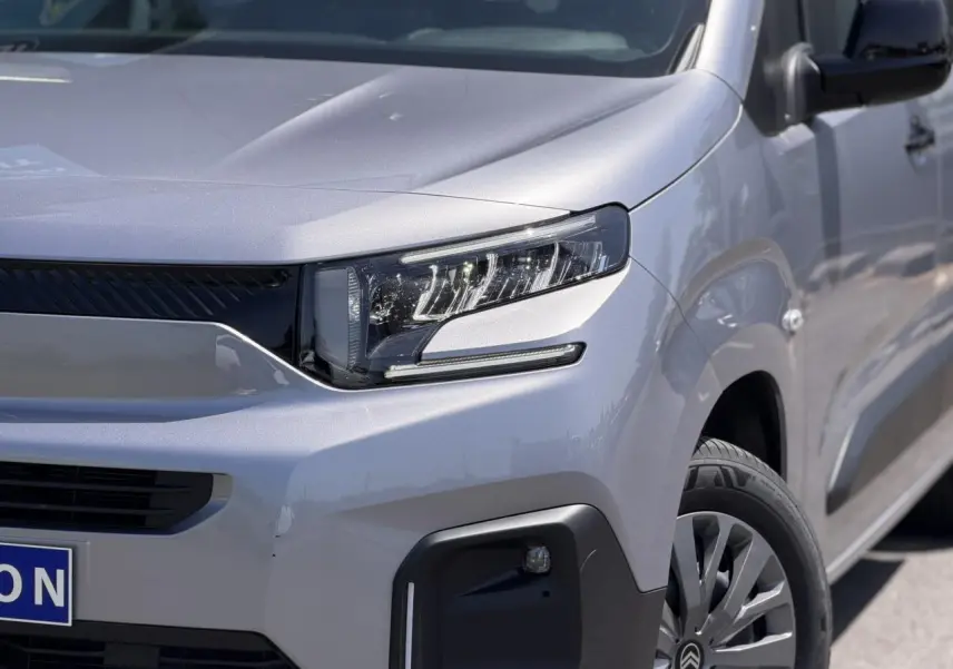 Vue 3/4 avant droit du Citroën Berlingo ë-136 gris Artense avec phares LED et jantes tôles 16 pouces.
