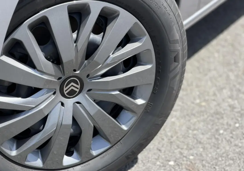 Gros plan sur la jante tôlée 16 pouces gris Artense du Citroën Berlingo ë-136 électrique, avec logo Citroën central.