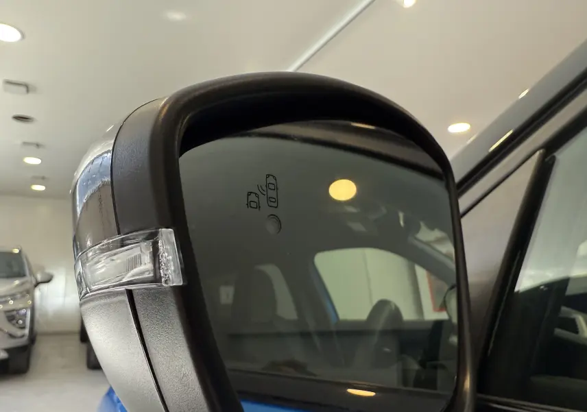 Rétroviseur extérieur droit du Peugeot 2008 bleu Vertigo avec clignotant intégré, intérieur visible en reflet.