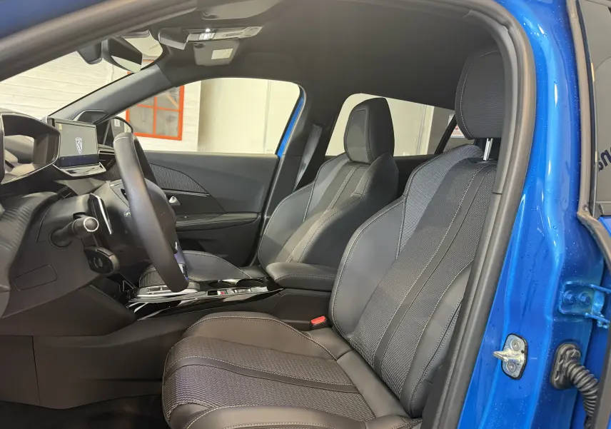 Vue intérieure côté conducteur du Peugeot 2008 2025 bleu Vertigo avec sièges sport en cuir et tissu gris.