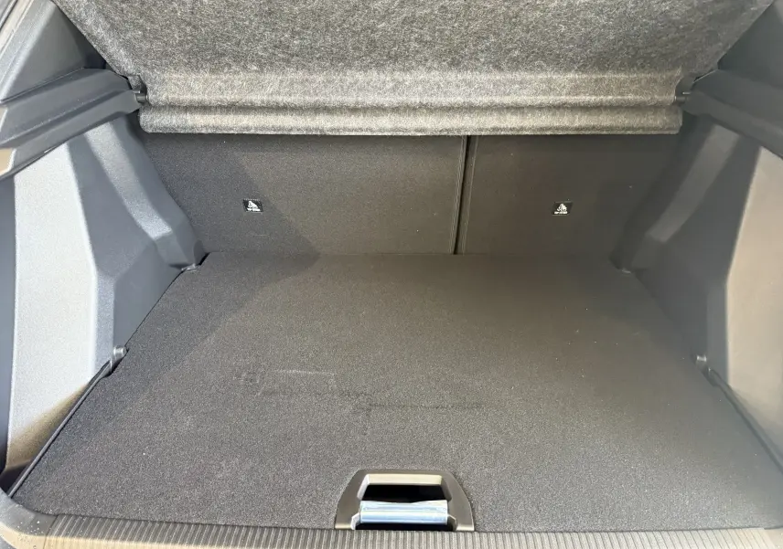 Coffre ouvert du Peugeot 2008 GT 2025, vue intérieure arrière, avec revêtement noir et tapis de sol plat.