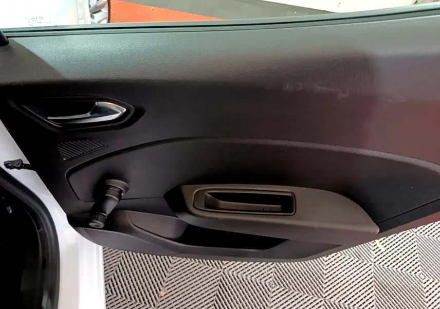 Vue intérieure côté gauche de la porte arrière blanche de la Renault Clio Business TCe 90 avec poignée et manivelle de vitre.