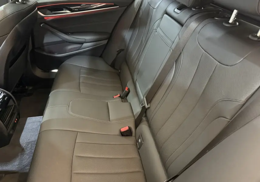 Vue intérieure côté droit de la banquette arrière en cuir noir de la BMW Série 5 Touring 520d M Sport 2023.