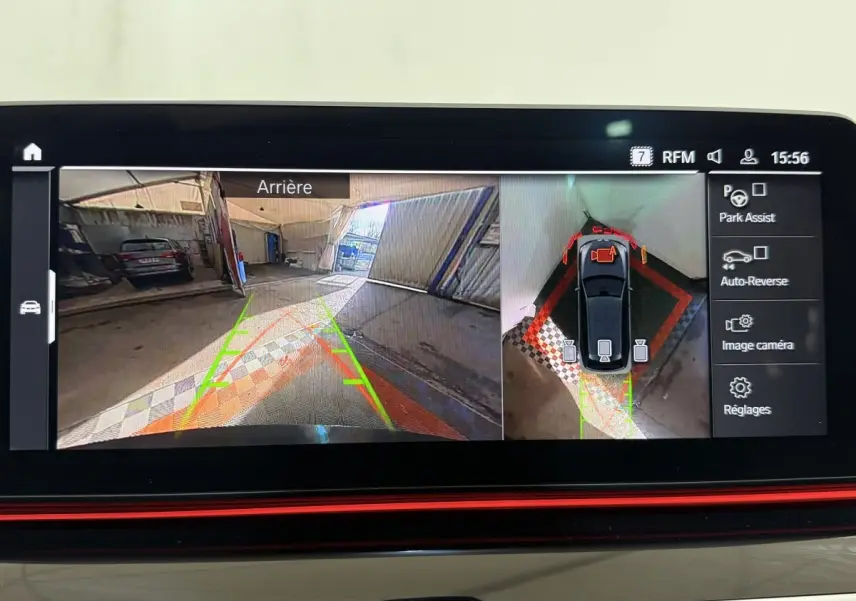 Écran de caméra de recul et vue aérienne du stationnement d’une BMW Série 5 Touring noire en intérieur.