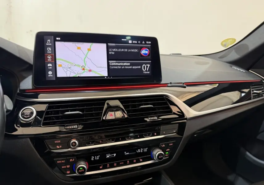 Vue intérieure du tableau de bord de la BMW Série 5 Touring 520d M Sport 2023 avec écran tactile et finition noire brillante.