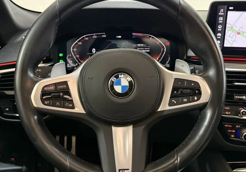Vue rapprochée du volant cuir noir M Sport et du combiné d'instruments numérique de la BMW Série 5 Touring 520d 2023.