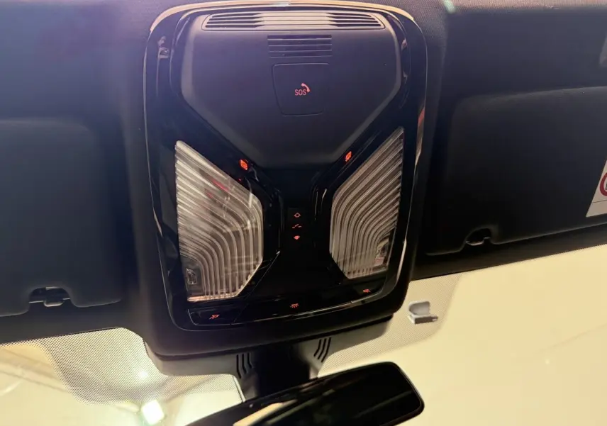 Plafonnier noir avec commandes éclairage et bouton SOS, vue intérieure avant du BMW Série 5 Touring 520d 2023.