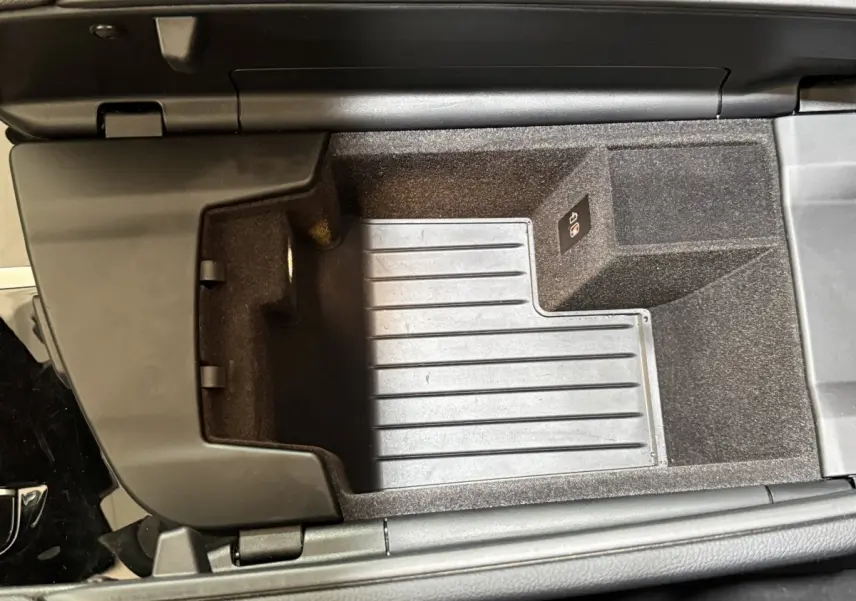 Vue plongeante sur le rangement central intérieur noir de la BMW Série 5 Touring 520d M Sport 2023.