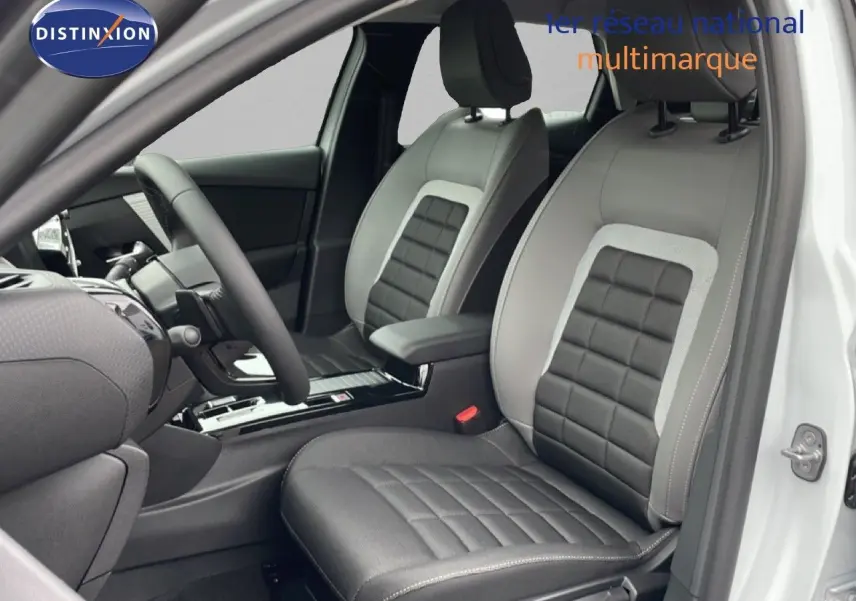 Vue intérieure côté conducteur de la Citroën C4 blanc métal, sièges en cuir noir et gris avec console centrale moderne.