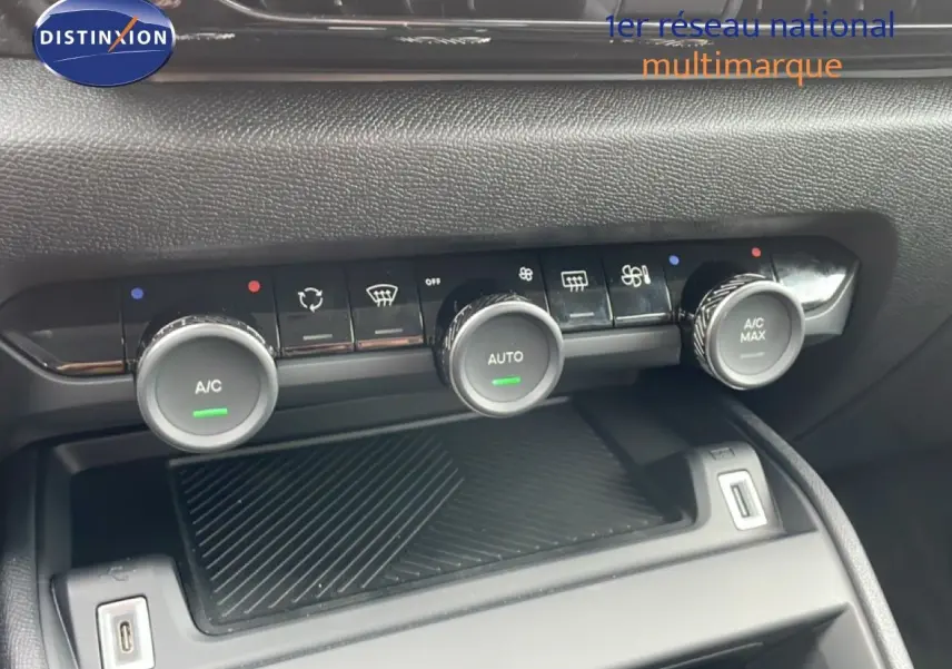 Gros plan sur la console centrale de la Citroën C4 blanche, mettant en valeur les commandes de climatisation automatique.