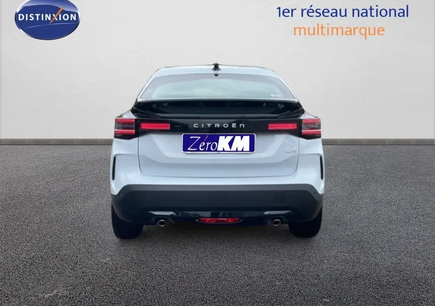 Vue arrière d'une Citroën C4 blanc métal avec toit noir, feux LED et double sortie d'échappement visible.